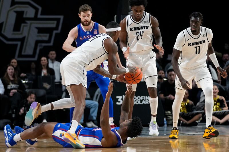 Central Florida’s C.J. Walker, front left, grabs the ball from Kansas’ K.J. Adams Jr. on Jan. 10, 2024, in Orlando.