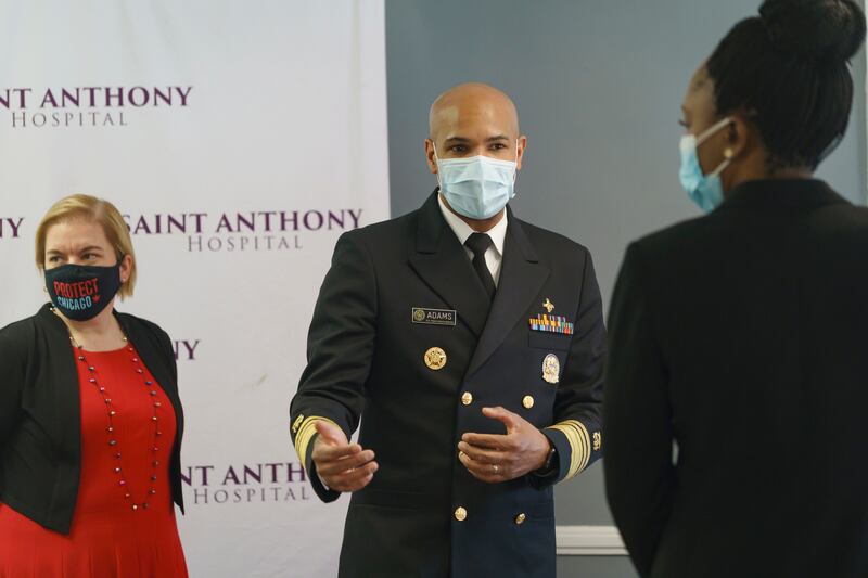 U.S. Surgeon General Jerome Adams, center, is joined by Chicago Health Commissioner Dr. Allison Arwady, left, and Illinois Public Health Director Dr. Ngozi Ezike during their visit at Saint Anthony Hospital in Chicago, Tuesday, Dec. 22, 2020.