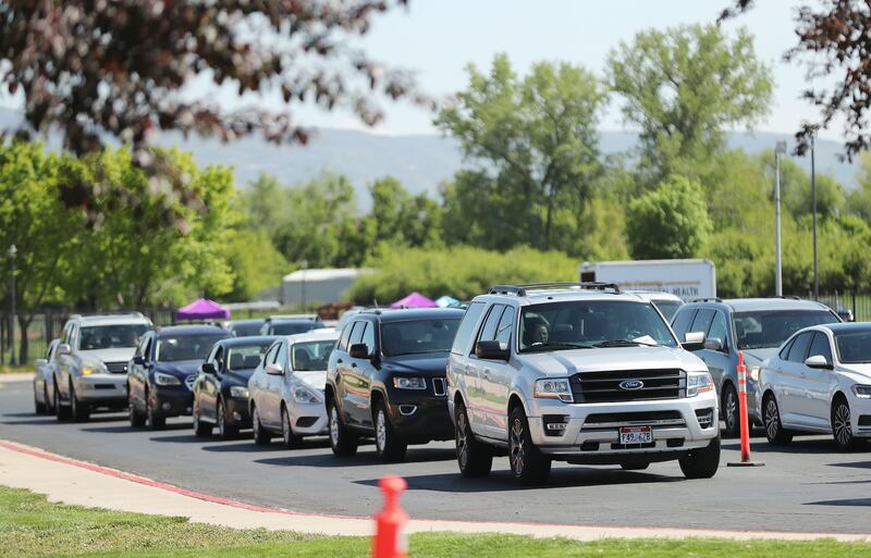 People wait in their cars for COVID-19 vaccines at the Legacy Events Center in Farmington, Utah.