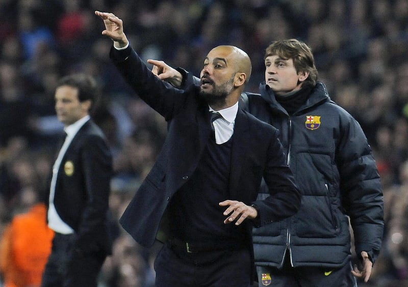 In this Tuesday April 3, 2012 photo FC Barcelona's coach Pep Guardiola, left, gives instruction to his team as FC Barcelona's assistant coach Tito Vilanova, right behind, gestures, during their Europa Champions League second leg, quarterfinal soccer match