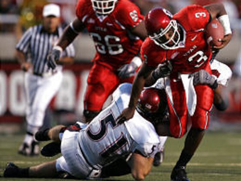 Utah quarterback Brian Johnson is dragged down by Aztecs' Joe Martin (51) and Kick Osborn.