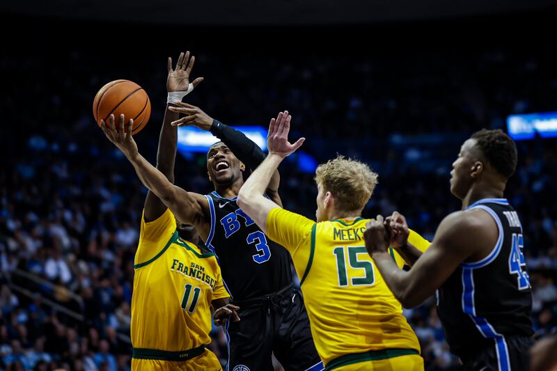 BYU guard Rudi Williams pushes through San Francisco defenders to put up a shot.