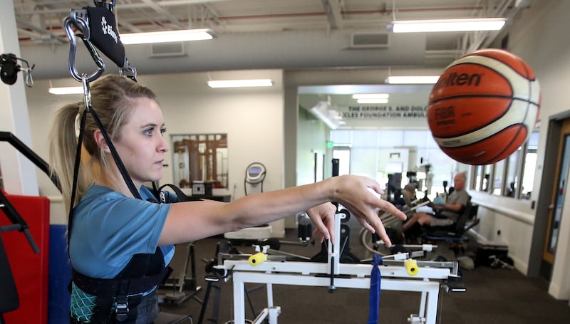 Kendal Levine, who was hit by a car while on a mission in Australia, passes a basketball as she works with physical therapist Marissa Moran at Neuroworx in Sandy on Thursday, April 25, 2019.
