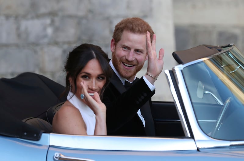 FILE - In this Saturday, May 19, 2018 file photo the newly married Duke and Duchess of Sussex, Meghan Markle and Prince Harry, leave Windsor Castle in a convertible car after their wedding in Windsor, England, to attend an evening reception at Frogmore House, hosted by the Prince of Wales.
