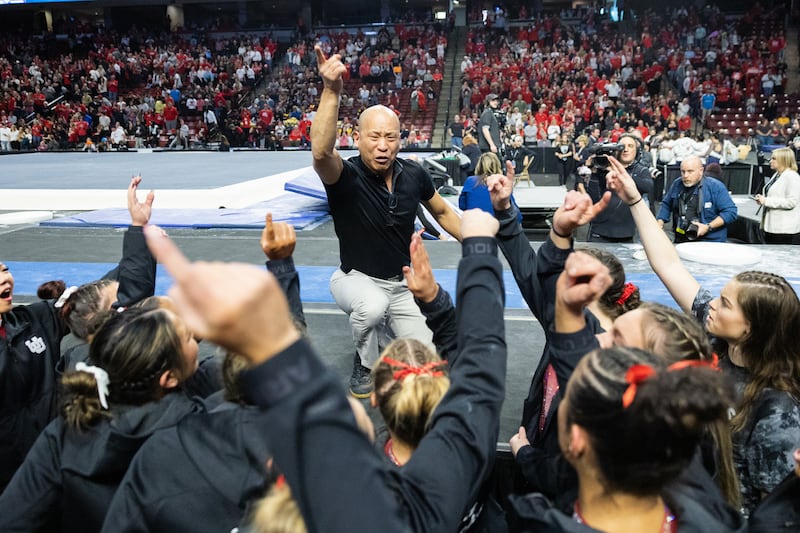 Utah’s head coach Tom Farden leads the team in a chant after winning the Pac-12 Gymnastics Championships.