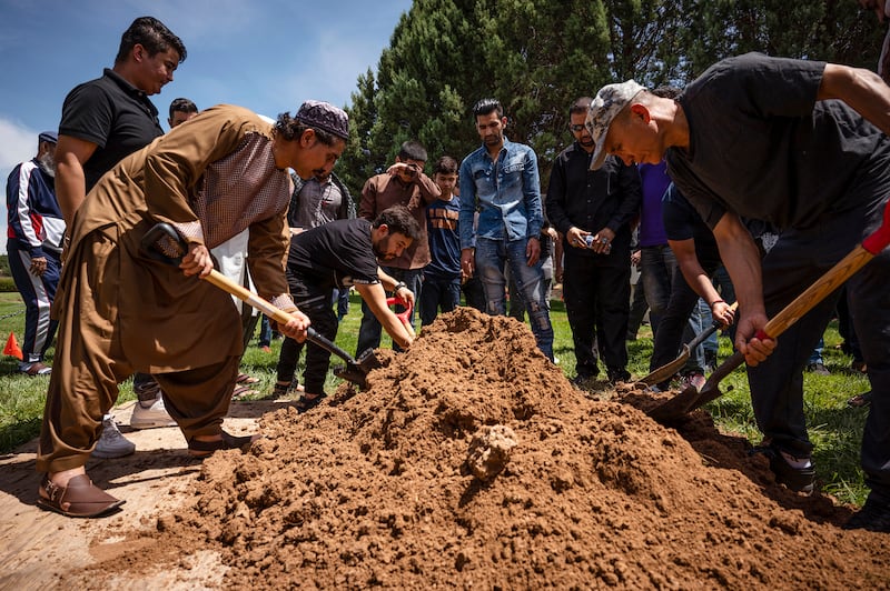 People spread dirt over Aftab Hussein’s grave at Fairview Memorial Park in Albuquerque, New Mexico.