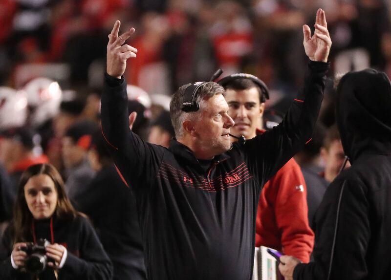 Utah Utes head coach Kyle Whittingham hold his arms up to encourage fans to make noise