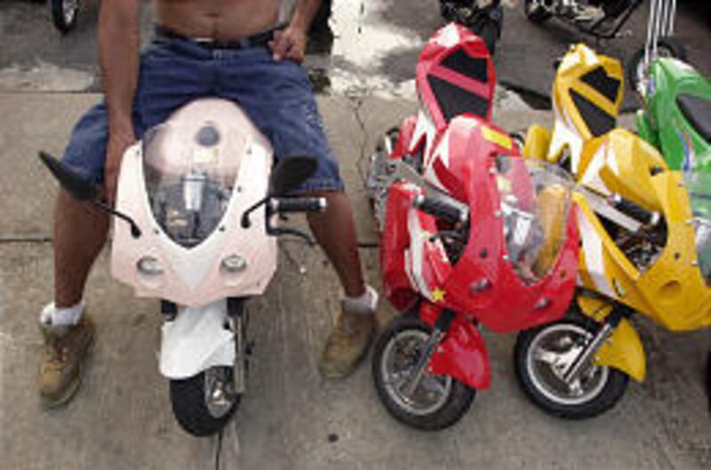 A youth sits on a pocket bike for sale at Piloto Auto Sales in North Philadelphia. The pocket bikes are small versions of regular-size motorcycles and are the latest summer rage across the United States and in Utah.