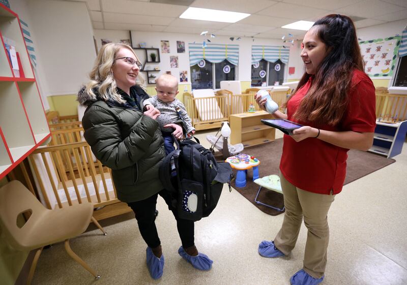 Kelsey Hixson-Bowles talks to Noemi Lugo, infant teacher, as she picks up her daughter River Hixson-Gray from La Petite Academy of Sandy in Sandy on Friday, Jan. 19, 2018.