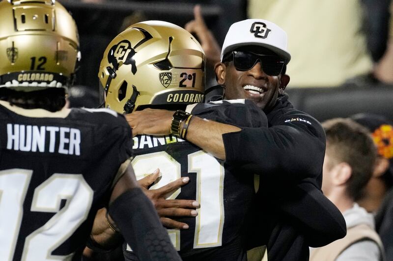 Colorado coach Deion Sanders, right, hugs his son, Shilo Sanders, after he returned an interception for a TD vs. CSU.