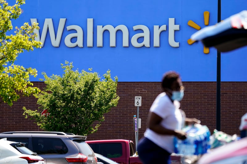 A shopper loads items into her car in the parking lot of a Walmart in Willow Grove, Pa.