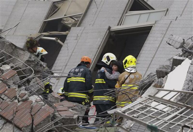 A young girl is rescued from a collapsed building after an earthquake in Tainan, Taiwan, Saturday, Feb. 6, 2016. A powerful, shallow earthquake struck southern Taiwan before dawn Saturday.