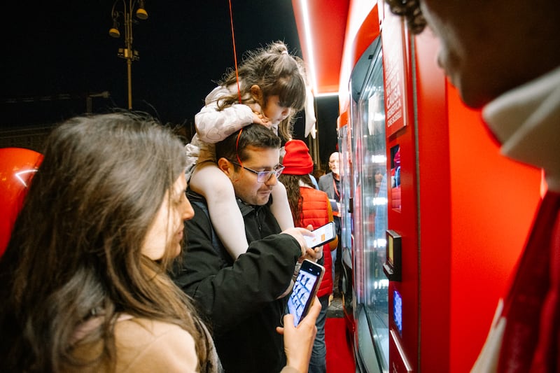 A young family makes a donation using one of the new Giving Machines that opened in Rome, Italy, on Monday, Dec. 8, 2025.