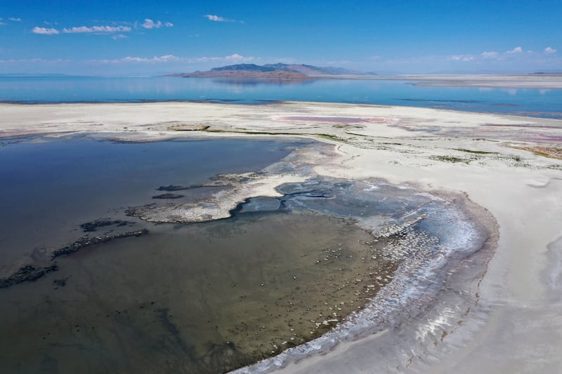 The Great Salt Lake at low levels receding from Antelope Island with an exposed lake bed.