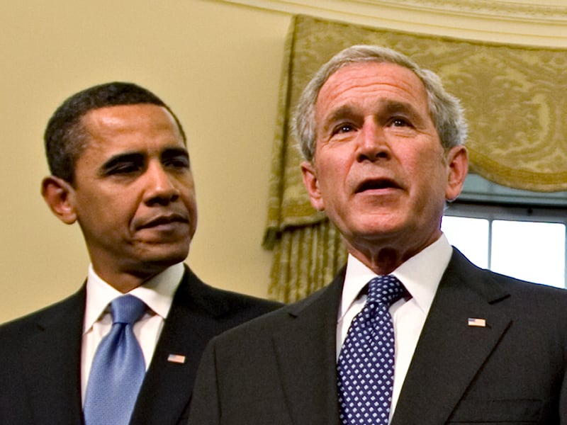 Then President-elect Barack Obama watches as then-President George W. Bush speaks.