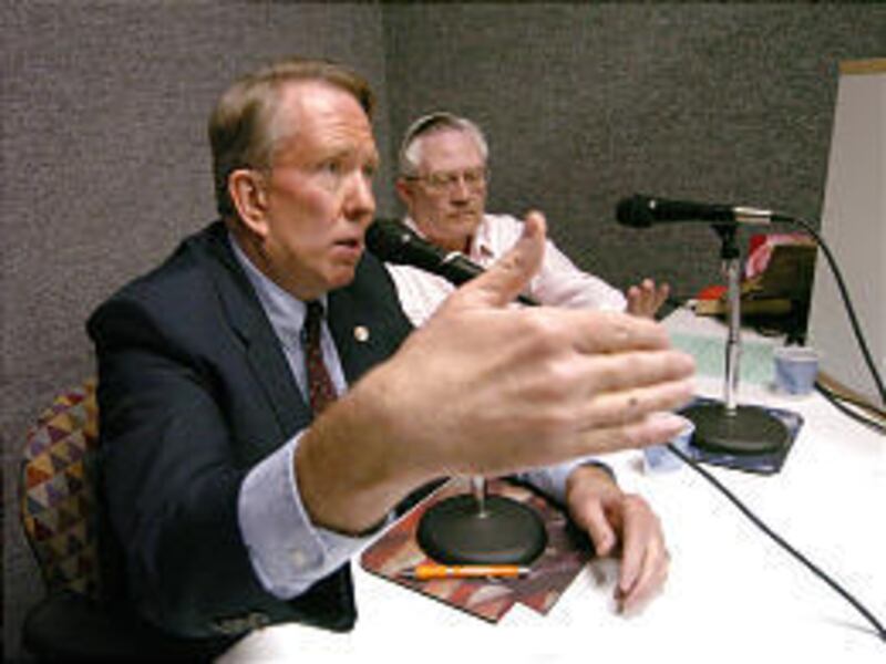 Merrill Cook speaks on immigration as adviser Russell Sias looks on.