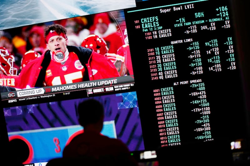 A person gambles as betting odds for the Super Bowl are displayed on monitors at the Circa resort and casino sports book Friday, Feb. 3, 2023, in Las Vegas.