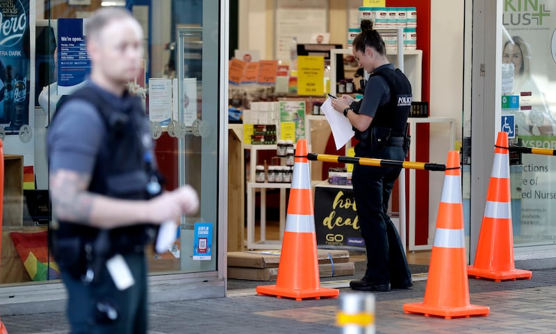 Police queue outside a pharmacy for their influenza injection in Christchurch, New Zealand, Thursday, March 26, 2020.
