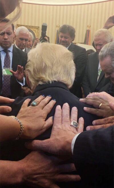 Evangelical supporters place hands on and pray with President Trump in the Oval Office of the White House.