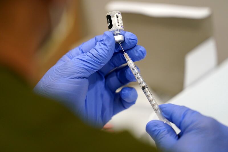 A health care worker fills a syringe with the Pfizer COVID-19 vaccine at Jackson Memorial Hospital on Oct. 5, 2021, in Miami.
