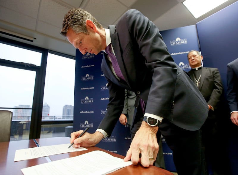 Derek Miller, Salt Lake Chamber president and CEO, signs the Utah Compact, a set of principles to guide the immigration discussion, during a press conference at the Salt Lake Chamber in Salt Lake City on Thursday, March 21, 2019.
