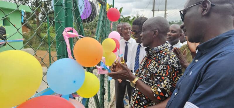 Chief Nana Agyapong Boateng cuts a ribbon formalizing the handover of the borehole on July 22, 2025, in Addokrom, Ghana.