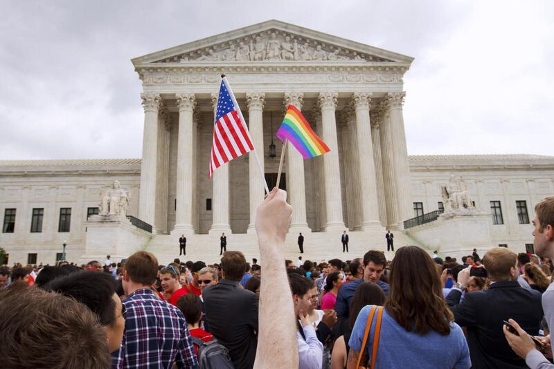 In this Friday June 26, 2015, file photo, a man holds a U.S. and a rainbow flag outside the Supreme Court in Washington after the court legalized gay marriage nationwide. After the decision, religious conservatives are focusing on preserving their right t