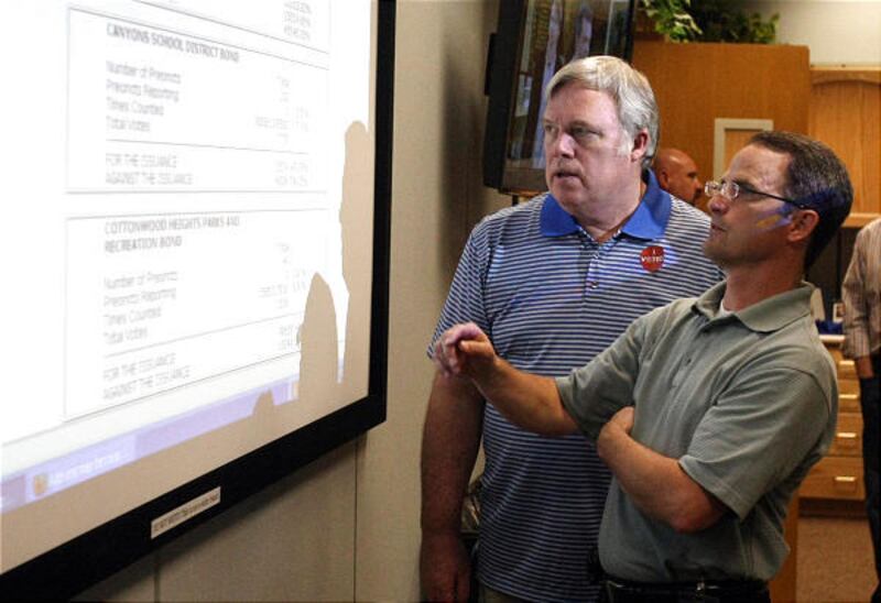 Canyons School Board member Kevin Cromar, left, and assistant superintendent Robert Dowdle watch as votes come in.