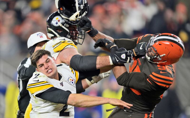 Cleveland Browns defensive end Myles Garrett (95) hits Pittsburgh Steelers quarterback Mason Rudolph (2) with a helmet during the second half of an NFL football game Thursday, Nov. 14, 2019, in Cleveland. (AP Photo/David Richard)
