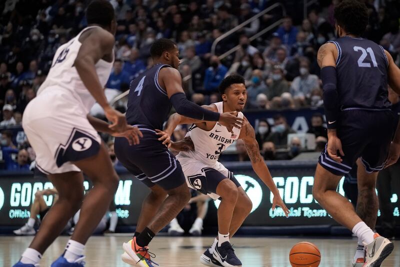 Brigham Young Cougars guard Te’Jon Lucas, wearing white, drives on San Diego Toreros forward Josh Parrish