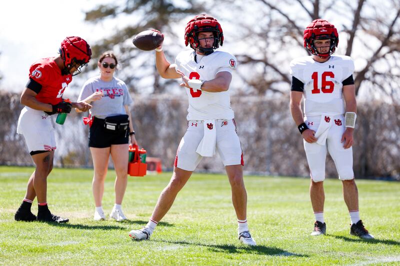 Backup quarterback Brandon Rose throws a pass during Utes spring drills while fellow backup Bryson Barnes looks on.