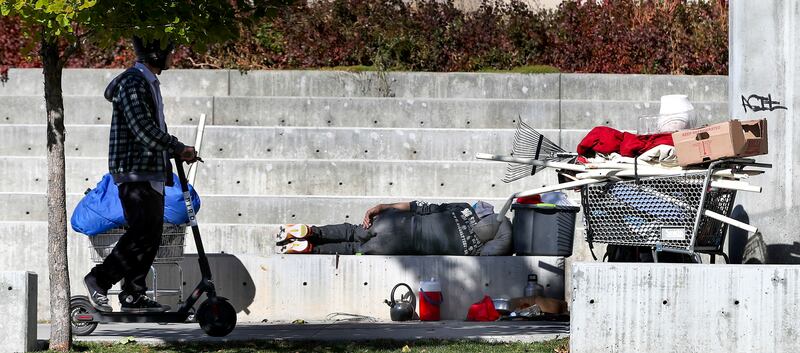 A man sleeps on a concrete wall at the Salt Lake City Public Safety Building on Thursday, Oct. 18, 2018.