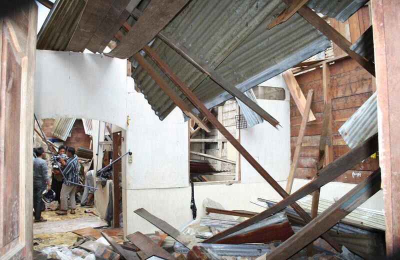 Residents take their properties from a damaged house Tuesday, Sept. 6, 2011 in Subulussalam, Aceh Province, Indonesia. A powerful earthquake rocked the region in western Indonesian island of Sumatra early in the day, killing a 12-year-old boy and sending