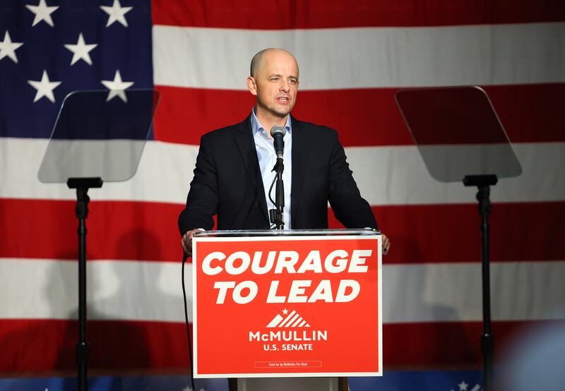 Evan McMullin stands to speak at a pulpit with a campaign sign that reads “Courage to lead” in front of a large American flag.