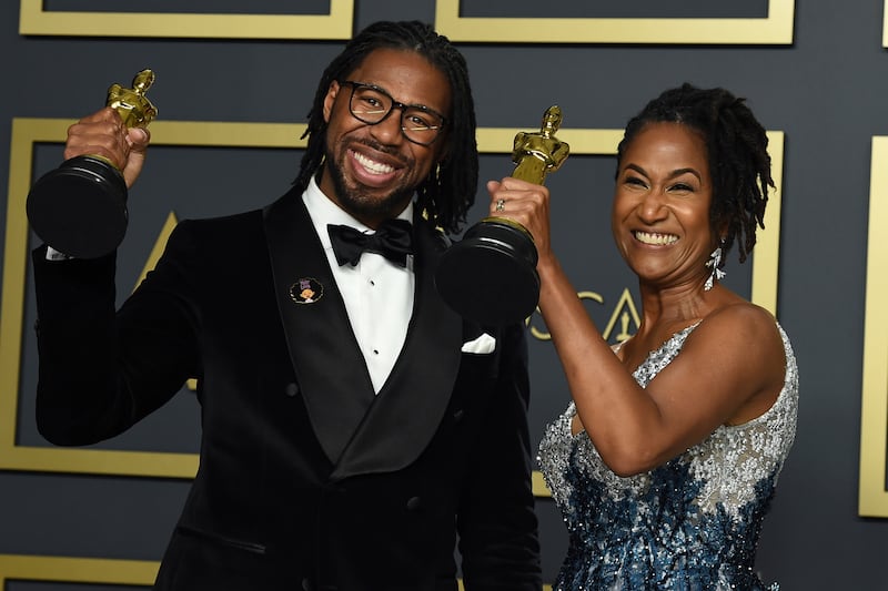 Matthew A. Cherry, left, and Karen Rupert Toliver, winners of the award for best animated short film for “Hair Love”, pose in the press room at the Oscars on Sunday, Feb. 9, 2020, at the Dolby Theatre in Los Angeles.