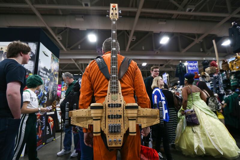 A man with an instrument shaped like a plane from "Star Wars" walks through the crowd during the FanX Spring Comic Convention at the Salt Palace Convention Center in Salt Lake City on Friday, April 19, 2019.