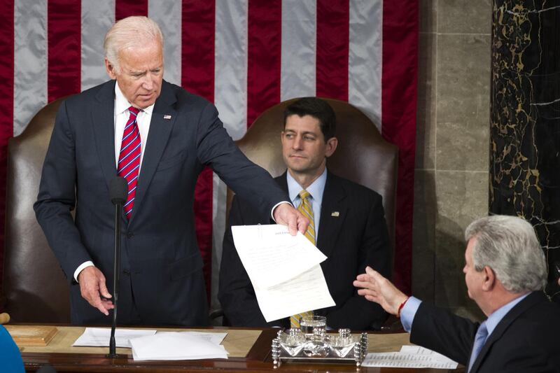 Vice President Joe Biden presents an Electoral College ballot to Rep. Robert Brady, D-Pa., right, to be certified as House Speaker Paul Ryan of Wis., watches during a joint session of Congress to count the electoral ballots, on Capitol Hill in Washington,