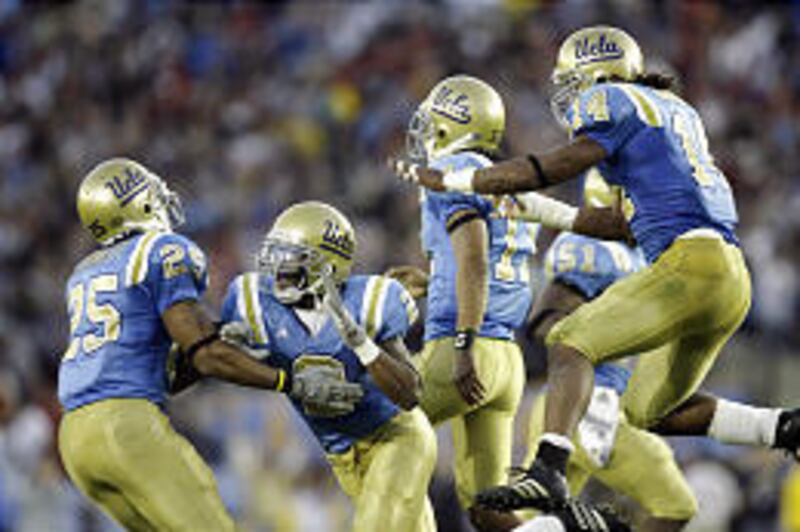 From left, UCLA's Bret Lockett, Eric McNeal, Osaar Rasshan and Chris Horton celebrate after McNeal intercepted a pass late in the fourth quarter to beat No. 2 USC.