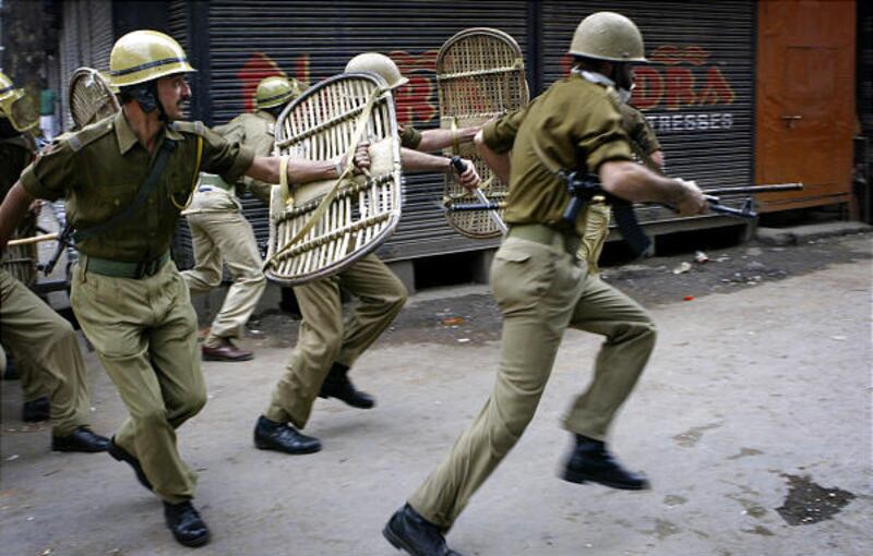 Police officers chase Kashmiris protesting Indian rule in Srinigar, India, on Friday. The strike coincided with U.N. Day.