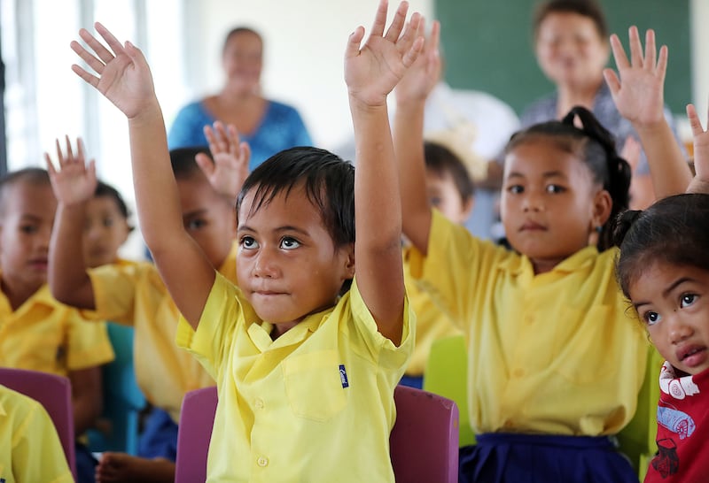Julie Tialino, center, raises her arms while singing a song during Foundational Learning preschool at the Siumu Ward in Siumu, Samoa, on Thursday, May 16, 2019.