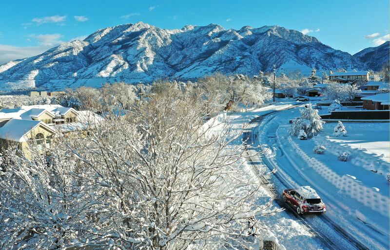A motorist drives on a plowed street.