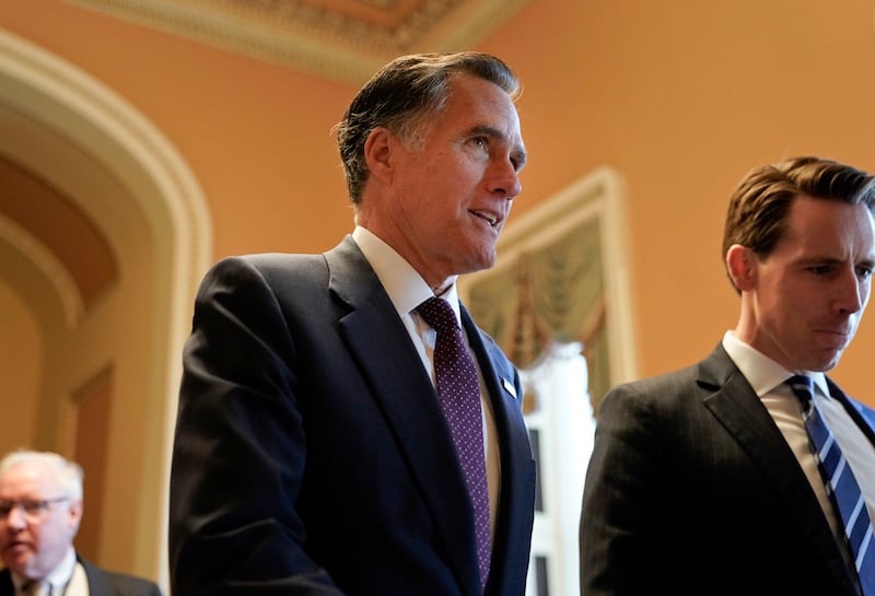 FILE - In this Nov. 14, 2018, file photo, Sen.-elect Mitt Romney, R-Utah, center, walks the hallway on Capitol Hill in Washington. Romney is a man in-between. He made it to Washington after all \_ but not as president of the United States, the office he s