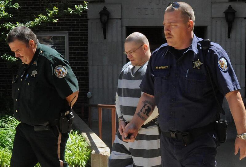 FILE - In this April 19, 2012, file photo, Jerry D. Lard, center, is escorted from the Craighead County Courthouse in Jonesboro, Ark. Lard is charged with capital murder and attempted capital murder for killing Trumann, Ark., police officer Jonathan Schmi