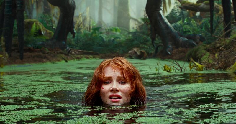 Bryce Dallas Howard (Claire Dearing) jumps into a swamp to escape a dinosaur attack in “Jurassic World: Dominion,” which opens Friday, June 10, 2022.