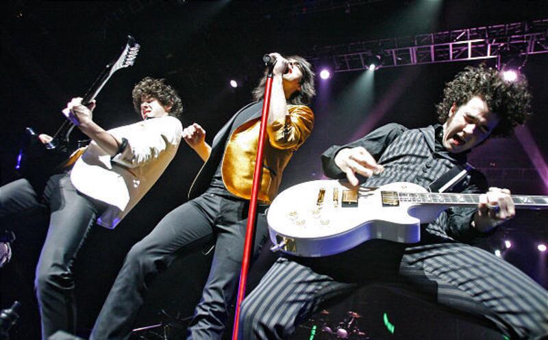 The energetic Jonas Brothers — Nick, left, Joseph and Kevin — perform before thousands of screaming fans at the E Center Friday.
