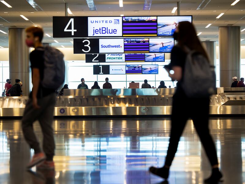 Travelers walking in the Salt Lake City International Airport baggage claim.