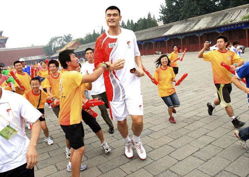 NBA Houston Rockets basketball team center and Chinese Olympic basketball star Yao Ming is mobbed by fans after running in the Olympic torch relay at Forbidden City, Wednesday.