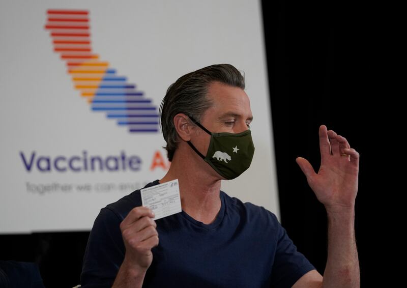 California Gov. Gavin Newsom holds up his new COVID-19 Vaccination Record Card after being inoculated with the new one-dose Janssen COVID-19 vaccine by Johnson & Johnson at the Baldwin Hills Crenshaw Plaza in Los Angeles Thursday, April 1, 2021. California has administered more than 18 million doses as of Thursday and 6.7 million people are fully vaccinated.