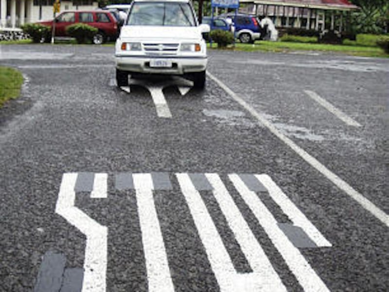 A car drives against a painted traffic sign in Apia, Samoa, before the switch.