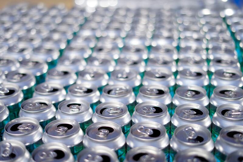 Hundreds of empty cans of beer are the result of making bottles of hand sanitizer at Silver Bear Distillery Tuesday, April 14, 2020 in Dalton, Mass. Bjorn O. Peter Sternerup, owner of Silver Bear Distillery has been working around the clock. His small distillery has been licensed by the FDA under an emergency order to produce hand sanitizer to WHO standards. (Ben GArver/The Berkshire Eagle via AP)